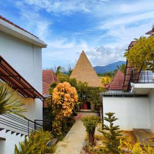 einen Innenhof eines Hauses mit einer Pyramide im Hintergrund in der Unterkunft Exotic Komodo Hotel in Labuan Bajo