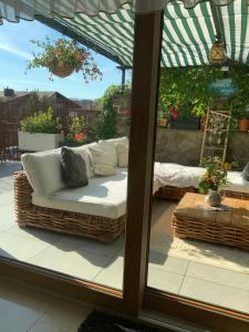 a patio with a wicker couch on a patio at Willa Sisi in Krynica Zdrój