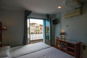 Un pat sau paturi într-o cameră la Hotel Hispania