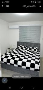 een zwart-wit geruit bed in een kamer bij Suit November in Majdal Shams