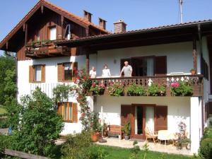 trzy osoby stojące na balkonie domu w obiekcie Haus Elisabeth w mieście Unterwössen