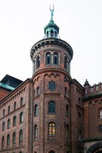 un bâtiment en brique avec une tour d'horloge en haut. dans l'établissement Hotel Ottilia by Brøchner Hotels, à Copenhague