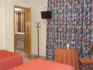 a room with a wall covered in books at Hostal Casa Juan in Lorca