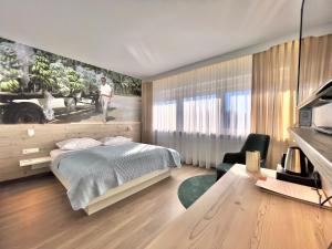 a bedroom with a bed and a desk with a chair at ART-Hotel Braun in Kirchheimbolanden