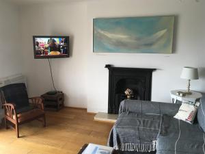 ein Wohnzimmer mit einem Sofa und einem TV an der Wand in der Unterkunft Moray Hastings in Hastings