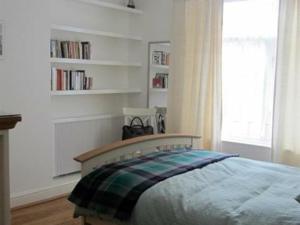 Schlafzimmer mit einem Bett, einem Fenster und Bücherregalen in der Unterkunft Moray Hastings in Hastings
