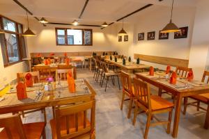 a restaurant with long wooden tables and chairs at ROKPA Guest House in Kathmandu