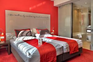 a bedroom with a large bed with a red wall at ART-Hotel Braun in Kirchheimbolanden