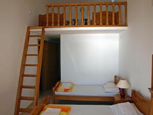 a bunk bed with a ladder and two beds in a room at Arabela Apartments in Utjeha