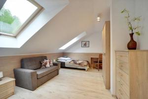 salon na poddaszu z kanapą i oknem w obiekcie Ekskluzywny Apartament Sun Seasons 24 w Karpaczu by Noclegi Renters w mieście Karpacz