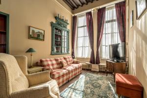 a living room with a couch and a tv at Job Baster Gastenverblijf in Zierikzee