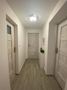 un corridoio vuoto con due porte e pavimenti in legno di Pokoje gościnne Izeria a Kamień