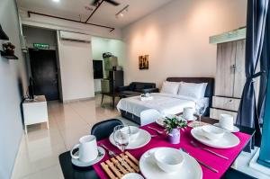 a room with a bed and a table with plates and wine glasses at 3 Towers Gleaneagles Jalan Ampang By IdealHub in Kuala Lumpur