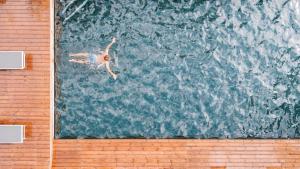 eine Person, die in einem Pool im Wasser schwimmt in der Unterkunft Parc Hotel Florian in Seis am Schlern