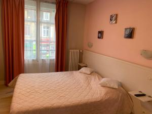 um quarto com uma cama e uma janela em Au Vieux Puits em Villers-Bocage