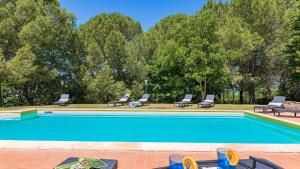 a swimming pool with two lounge chairs and a person sitting in avisor at Poggio Medei 10, Emma Villas in Città della Pieve