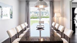 jadalnia ze stołem i krzesłami oraz dużym oknem w obiekcie PORTOVERDE BEACH VILLA 12, Emma Villas w mieście Misano Adriatico