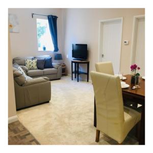 ein Wohnzimmer mit einem Sofa und einem Tisch in der Unterkunft Private 1st Floor Apartment - Perfect for Port of Dover, Eurotunnel and Short Stays in Dover