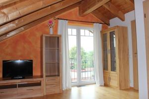 sala de estar con TV y ventana grande en Ferienwohnung Wühn, en Teisendorf