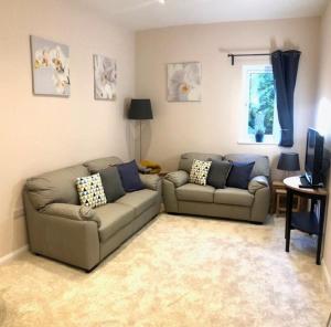 ein Wohnzimmer mit zwei Sofas und einem Fernseher in der Unterkunft Private 1st Floor Apartment - Perfect for Port of Dover, Eurotunnel and Short Stays in Dover