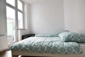 a bedroom with a bed with a blue comforter and a window at Apartment mit 2 Schlafzimmern in Bergisch Gladbach