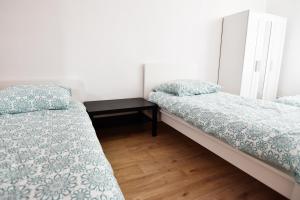 two beds in a small room with a table at Apartment mit 2 Schlafzimmern in Bergisch Gladbach +3 photos