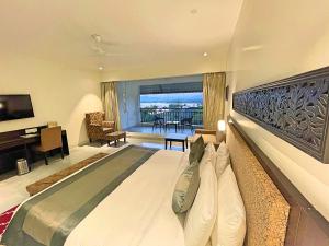 a bedroom with a large bed and a living room at TatSaraasa Resort & Spa, Udaipur in Udaipur