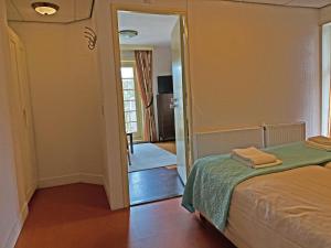 a bedroom with a bed and a door leading to a hallway at Villa Prinsenhof # Zeventien in Bergen