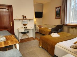 Habitación de hotel con 2 camas y mesa en Willa Iskra, en Zakopane