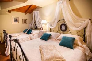 a bedroom with two beds with white sheets and blue pillows at Dimora di Charme Villa Sant'Erasmo in Fumone