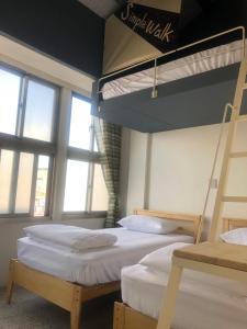 two bunk beds in a room with windows at Simple Walk Guest House 小公寓 in Tainan