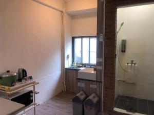 um banheiro com pia e box de vidro em Simple Walk Guest House 小公寓 em Tainan