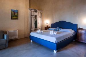 ein Schlafzimmer mit einem blauen Bett und einem Stuhl in der Unterkunft Agriturismo Pratello in Padenghe sul Garda
