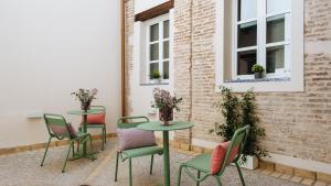 a patio with tables and chairs and windows at Magno Apartments Rocío in Seville