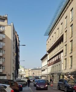 Mokotowska 67 by Homeprime في وارسو: شارع المدينة فيه سيارات تقف على الشارع