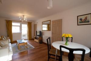a living room with a table and chairs and a living room at Surlingham Lodge Garden Cottage in Norwich