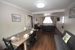 a dining room and living room with a table and chairs at Kenton House in Wealdstone