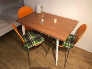 una mesa de madera con 2 sillas y aannel en Gästehaus Europa en Rust