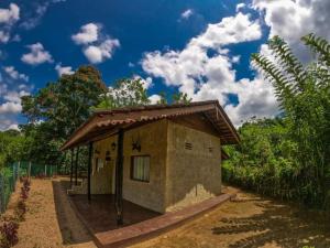 un pequeño edificio con techo en un camino de tierra en Kandy Okaya, en Kandy
