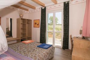 a bedroom with a bed and a large window at B&B La casa dei gelsi in Loano