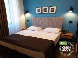 a bedroom with a large bed with a blue wall at Sabotin, Hotel & Restaurant in Nova Gorica