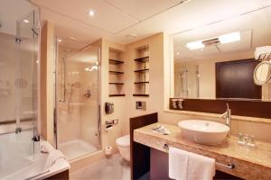 a bathroom with a sink and a shower and a toilet at Crowne Plaza Bratislava, an IHG Hotel in Bratislava