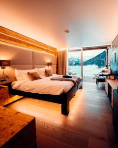 - une chambre avec un grand lit et une grande fenêtre dans l'établissement Au Club Alpin, à Champex-Lac