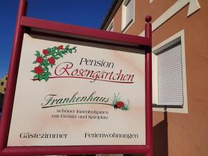 a sign for a restaurant on the side of a building at Pension Rosengärtchen in Absberg