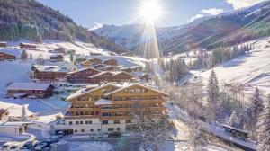 a ski lodge in the snow with the sun shining at Galtenberg Bed & Breakfast in Alpbach