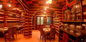 een restaurant met tafels en stoelen in een kamer met gestreepte muren bij Hotel Broadway Anneexy in Darjeeling