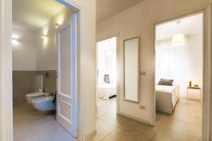 bagno con servizi igienici, letto e specchio di Magnolia - Civico 96 ad Alghero