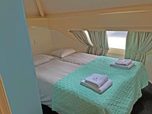 a small bedroom with two towels on a bed at Villa Prinsenhof # Tweeëntwintig in Bergen