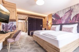 a bedroom with a large bed and a desk at Galtenberg Bed & Breakfast in Alpbach