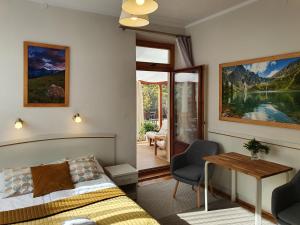 1 dormitorio con cama, escritorio y mesa en Willa Iskra, en Zakopane